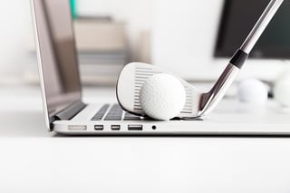 Golf ball resting on a laptop that represents the start of your relationship with your marketing agency